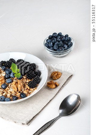 Healthy breakfast. Homemade granola, muesli, cereals with blackberries, blueberries, nuts, honey and Healthy breakfast. Homemade granola, muesli, cereals with blackberries, blueberries, nuts, honey and 55116317