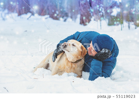 A happy man with a Labrador retriever dog lying in 55119023