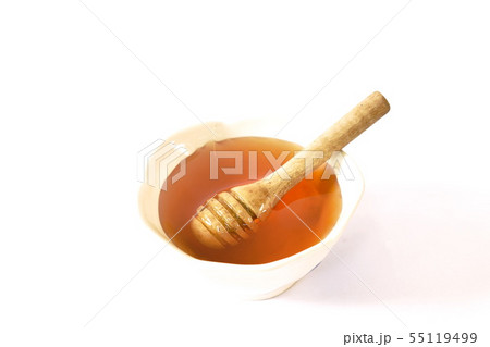 honey and wooden scoop in cup on white background 55119499