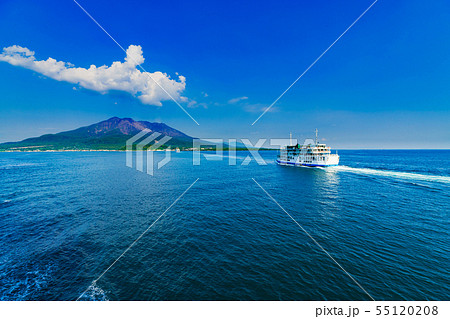 [鹿児島県の観光イメージ] 初夏の快晴の下，噴煙をあげる桜島に向かう桜島フェリーと海上の航跡 55120208