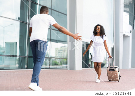 African guy picking up his girlfriend at airport African guy picking up his girlfriend at airport 55121341