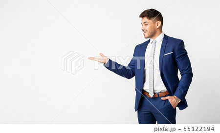Smiling Businessman Presenting Something On Empty Palm Over White Background 55122194