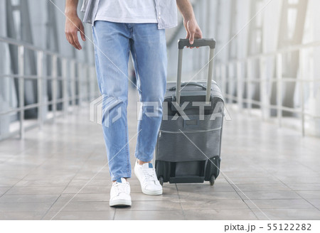 Man walking with luggage at airport corridor Man walking with luggage at airport corridor 55122282