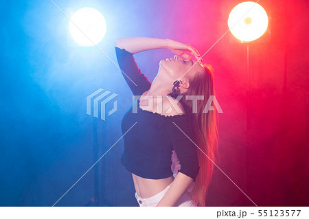 Dance, grace and elegance concept - young woman dancing bachata lady style in the dark, lights and Dance, grace and elegance concept - young woman dancing bachata lady style in the dark, lights and 55123577