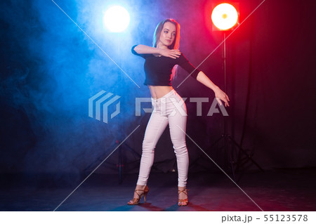 Nightlife and club concept - young woman dancing in the dark under the lights Nightlife and club concept - young woman dancing in the dark under the lights 55123578