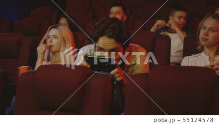 Man pirating movie with smartphone in cinema 55124578