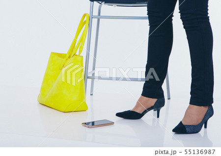 girl puts foot on phone. heel breaks smartphone. girl puts foot on phone. heel breaks smartphone. 55136987