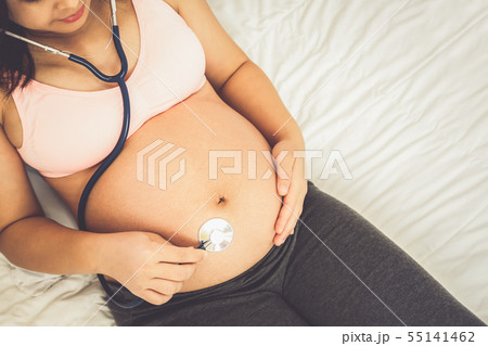 Happy pregnant woman and expecting baby at home. Happy pregnant woman and expecting baby at home. 55141462