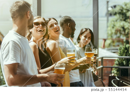 Young group of friends drinking beer and celebrating together 55144454