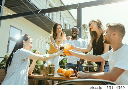 Young group of friends drinking beer and celebrating together Young group of friends drinking beer and celebrating together 55144569