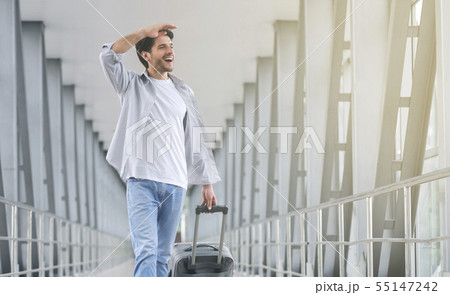 Happy traveler walking with suitcase in airport 55147242
