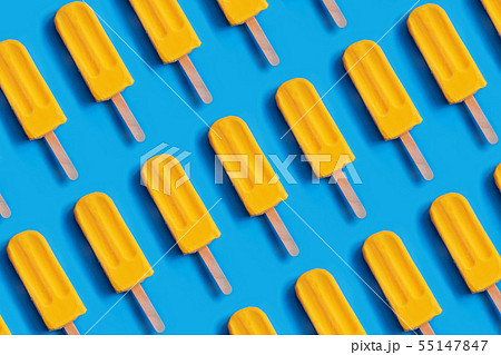 Pattern made of bright yellow mango ice cream on blue pastel background. 55147847