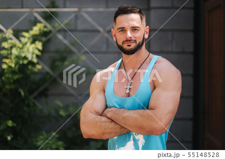 Handsome bodybuilder in blue singlet posing outside. Bearden men before training 55148528