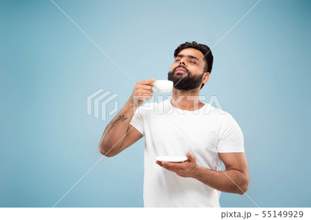 Half-length close up portrait of young man on blue background. 55149929
