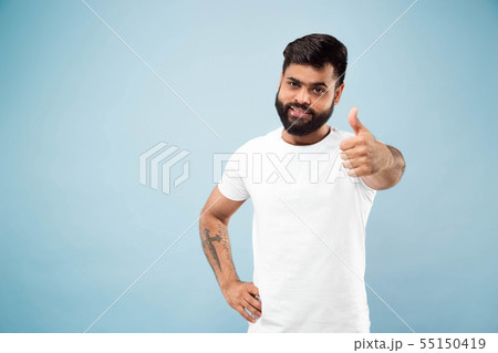 Half-length close up portrait of young man on blue background. 55150419