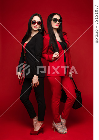 Brunettes in smart suits and glasses standing back 55151057