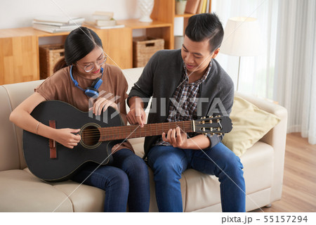 Couple learning to play guitar 55157294