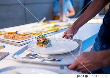 man picks up food at the buffet man picks up food at the buffet 55158389