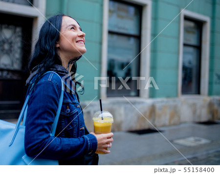 Woman in denim jacket with orange juice Woman in denim jacket with orange juice 55158400