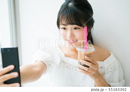 タピオカミルクティーと自撮りをする若い女の子 55163302