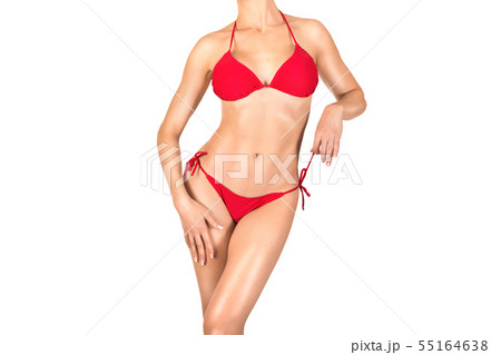 Sexy fit tanned female body in red bikini , isolated on white. Woman puts her hands on hips 55164638