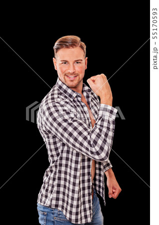 Attractive macho man flexing his arm muscles 55170593