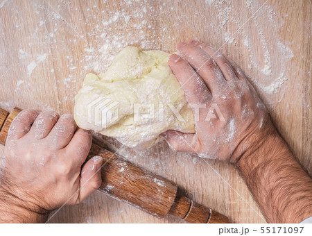 male chef kneads the dough 55171097