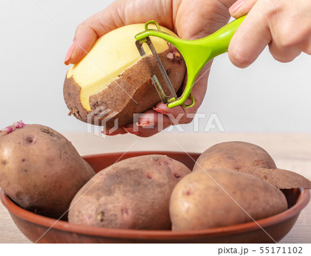 woman cook cleans potatoes 55171102