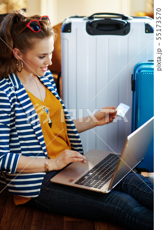 stylish woman with credit card booking tickets on laptop 55173570