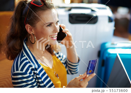 smiling stylish woman with credit card to pay for hotel room 55173600
