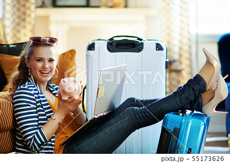 happy elegant woman booking tickets and showing piggy bank happy elegant woman booking tickets and showing piggy bank 55173626