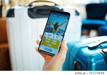 Closeup on female hand with smartphone booking tickets using app Closeup on female hand with smartphone booking tickets using app 55173649