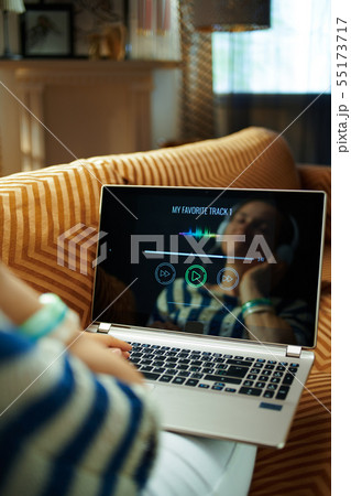 relaxed woman listening to music with headphones on laptop relaxed woman listening to music with headphones on laptop 55173717