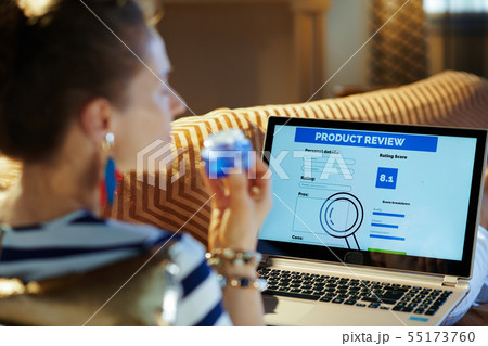 housewife writing review on laptop after beauty online shopping 55173760