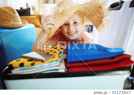 traveller girl with big beach straw hat packing for summer trave traveller girl with big beach straw hat packing for summer trave 55173817