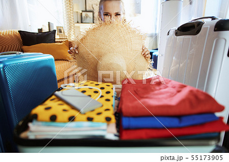 modern woman hiding behind big beach straw hat 55173905