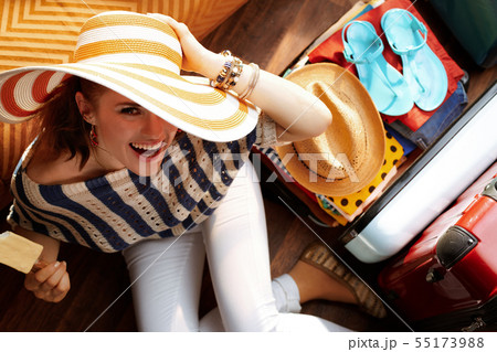 woman with big summer hat eating ice cream packing for holiday 55173988
