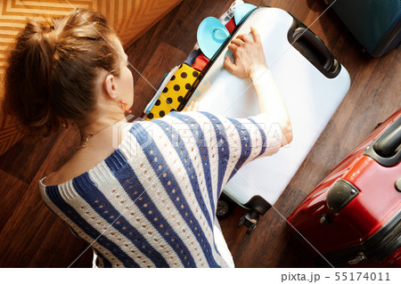 modern woman closing over packed suitcase modern woman closing over packed suitcase 55174011