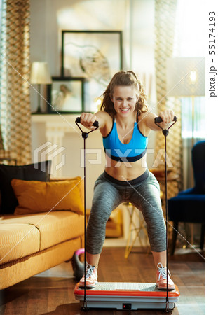 smiling sports woman training using vibration power plate smiling sports woman training using vibration power plate 55174193