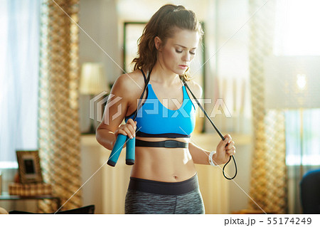 woman with a jump rope and heart rate monitor catching breath 55174249