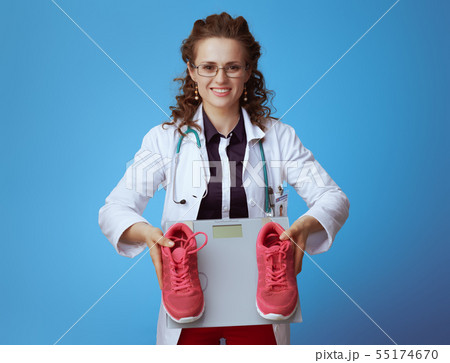 medical practitioner woman with weight scale and sneakers 55174670