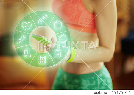 Closeup on smartphone in hand of fit woman watching fit videos Closeup on smartphone in hand of fit woman watching fit videos 55175014