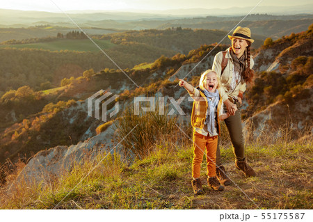 happy fit mother and child travellers pointing at something 55175587