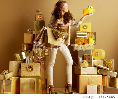 woman with shopping bags, credit cards looking at piggy bank 55175685