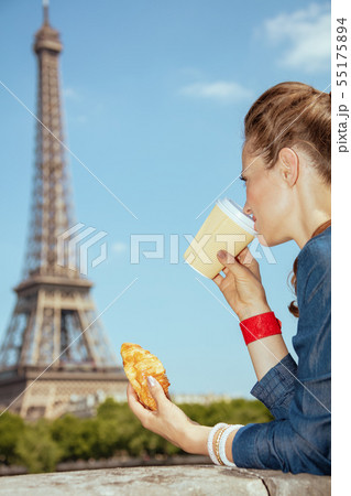 trendy solo traveller woman having coffee cup and croissant 55175894