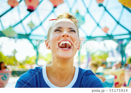 smiling fit woman in blue t-shirt in theme park having fun time smiling fit woman in blue t-shirt in theme park having fun time 55175914