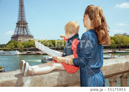 trendy mother and daughter tourists holding map and pointing 55175953