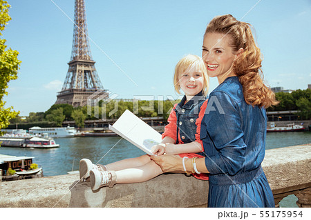happy stylish mother and child tourists with map 55175954