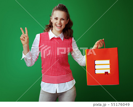 happy student with red shopping bag with books showing victory 55176049