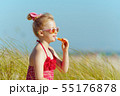 trendy girl applying lipstick with spf on ocean coast 55176878